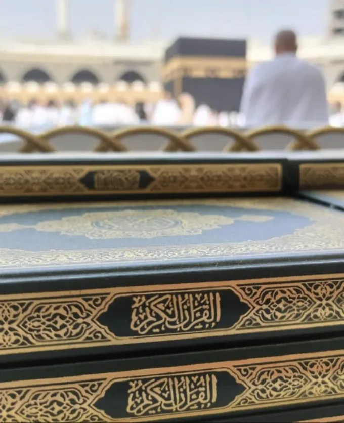 Corans déposés au Masjid al-Haram de Makkah avec la Kaaba en arrière-plan
